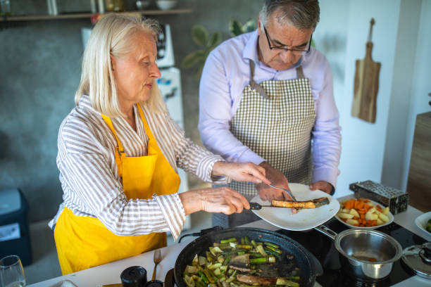 istock Senior couple preparing fish in electric cooker 1284026134