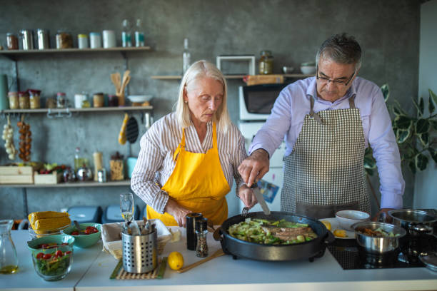 istock Senior couple preparing fish in electric cooker 1284026244