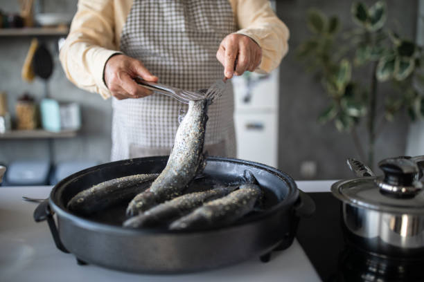 Chef preparing fish for lunch at home Chef preparing fish for lunch at home polytetrafluoroethylene photos stock pictures, royalty-free photos & images