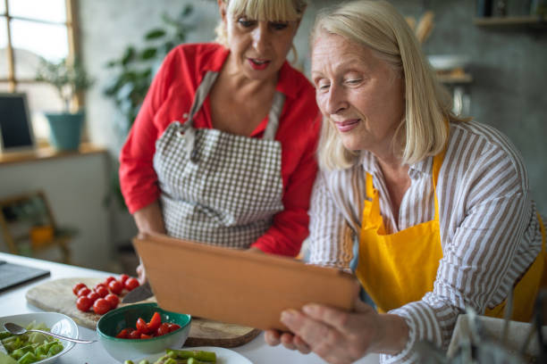 istock Two female senior chefs looking for healthy food recipes using digital tablet 1284026966