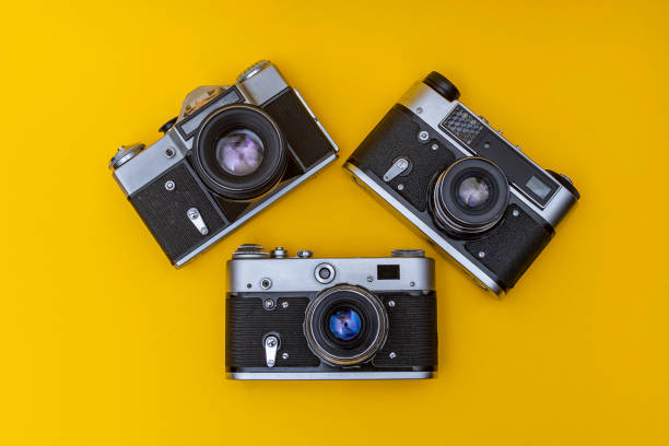 istock Old obsolete film cameras on yellow background 1284027152