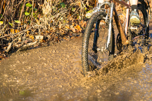 istock Riding bicycle in mud and water drops flying all over. 1284028634