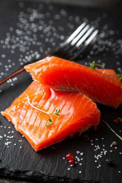 istock Pieces of smoked salmon on a black plate 1284028667