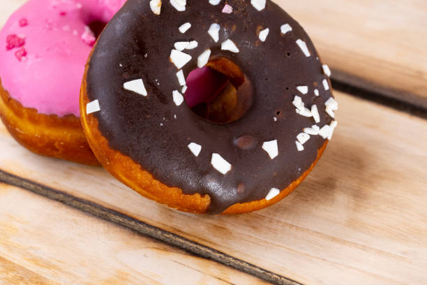 istock Two raspberry and chocolate donuts on a wooden background. Free space for text. World donut day 1284029201