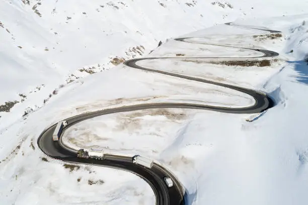 Aerial view of curvy winding road in Julier Pass, cars und truck driving, Swiss Alps, Graubunden Canton (Canton of Grisons).