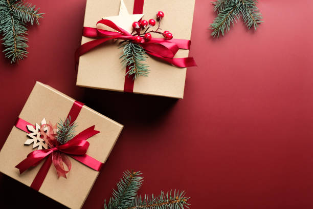 istock Christmas gift boxes with red ribbon bow and decorations on marsala red background. Flat lay, top view. Christmas presents. 1284031169