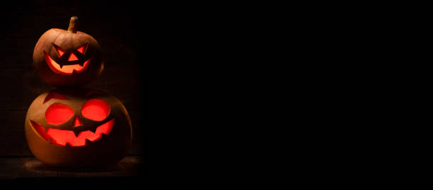 istock Two Halloween pumpkin with scary face. Jack-o-lantern in the dark 1284032647