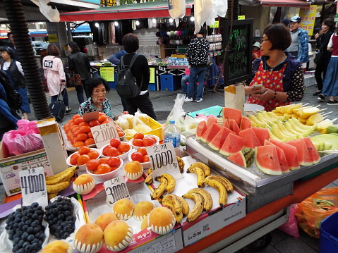 Seoul, South Korea, October 6, 2016: Two women at a fruit stall at the Namdaemun market. Seoul
