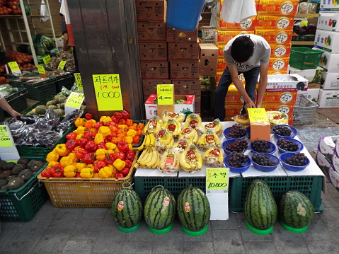 Seoul, South Korea, October 6, 2016: A man at a fruit stall at the Namdaemun market. Seoul