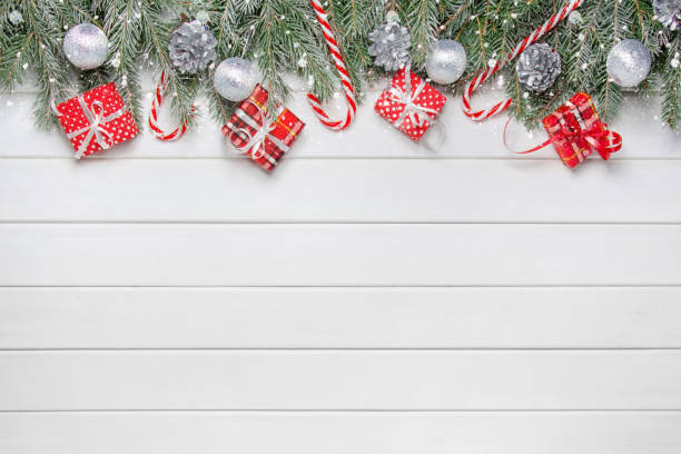 istock Christmas composition. Gifts, spruce branches, red and silver decorations on a white wooden background. Christmas, winter, new year concept. Flatlay, top view, copy space 1284034207