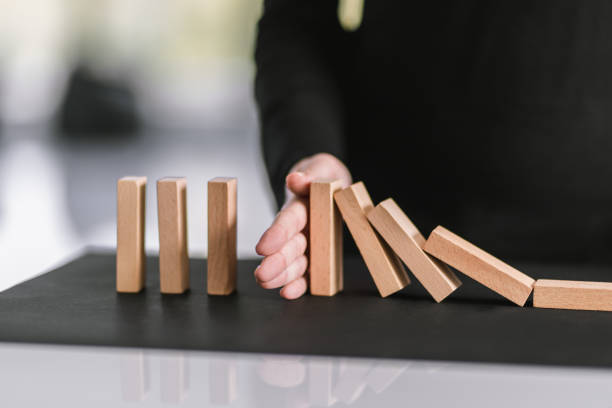istock Woman's hand Stop Domino Effect, Chain Reaction In Business Concept 1284034315