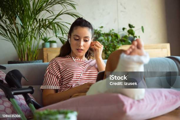 Young Woman With Broken Leg During Video Call Stock Photo - Download Image Now - Recovery, Domestic Life, Orthopedic Cast