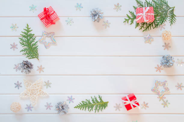 istock Christmas composition. Red gift box, silver snowflakes, thuja branches, pine cones and vintage star on white background. Top view, flat lay, copy space 1284035453