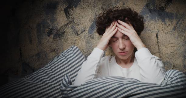 retrato de cintura para una mujer madura sentada en la cama y con insomnio - waistup fotografías e imágenes de stock