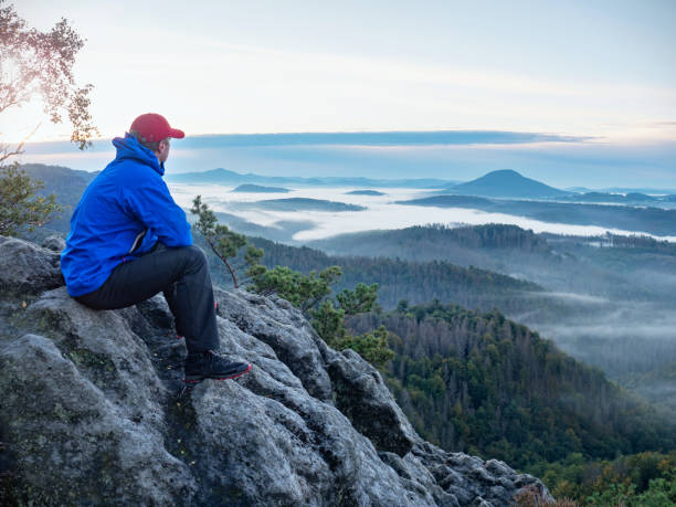 istock Man sit. Wonderful  view to heavy mist in deep valley 1284037290