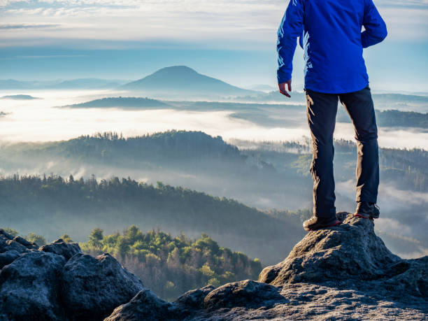 istock Man watch thick mist in valley from rocky view point 1284037380