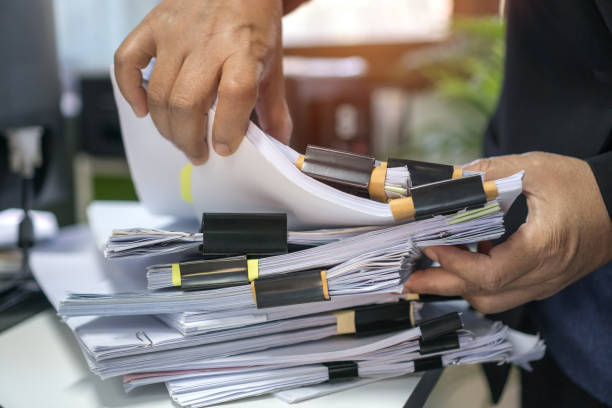 istock Office workers arranging stacks of lot paperwork files for searching infomation unfinished documents about audit form on desk offices, piles of investigate workload form for teacher school 1284038761