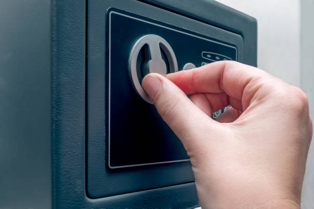 istock Close-up of a female hand opens a safe deposit. 1284039802