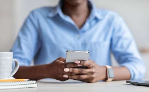 istock Unrecognizable African American Businesswoman Using Smartphone At Workplace In Office 1284041718