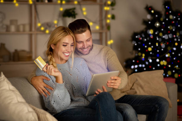 alegre esposo y esposa haciendo compras en línea - holiday shopping fotografías e imágenes de stock
