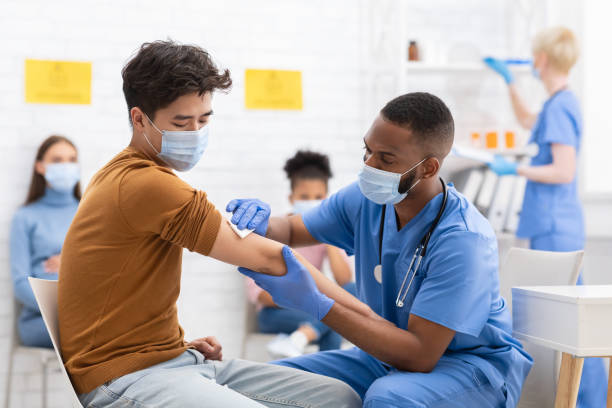 asiatischer männlicher patient wird gegen coronavirus im krankenhaus geimpft - asian ethnicity doctor patient healthcare and medicine stock-fotos und bilder