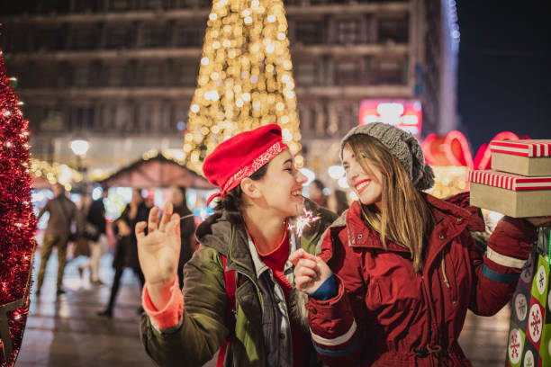 istock Two woman celebrating Christmas outdoors with sparkles 1284041893