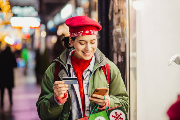 istock Young woman in a Christmas shopping using credit card 1284042649