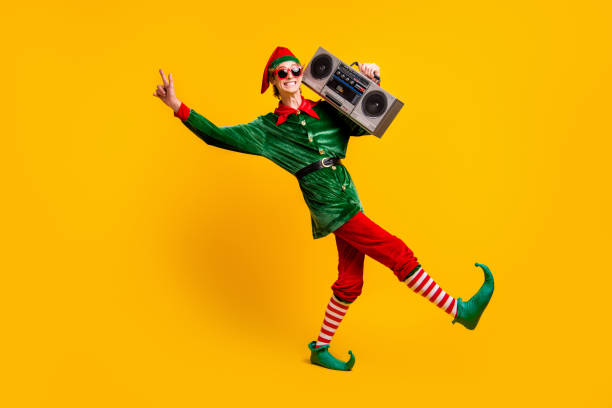 Full length body size view of his he nice attractive skinny cheerful cheery funny teenage guy elf carrying tape player dancing isolated over bright vivid shine vibrant yellow color background Full length body size view of his he nice attractive skinny cheerful cheery funny, teenage guy elf carrying tape player dancing isolated over bright vivid shine vibrant yellow color background elf photos stock pictures, royalty-free photos & images