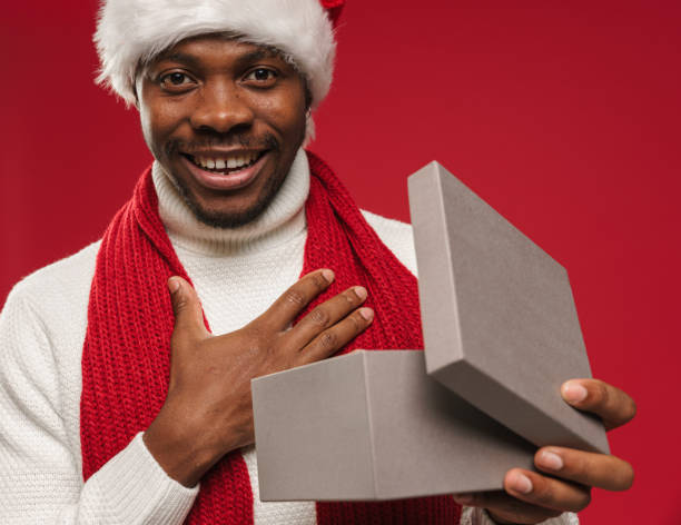 istock A young dark-skinned man receives a gift, opens it, touches his chest and smiles with appreciation 1284043124