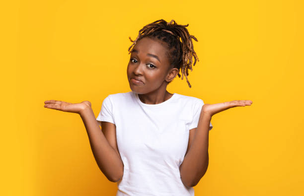 istock Confused black woman manraising her hands and looking at camera 1284043971