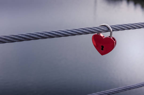 istock Red heart padlock with unfocused water background 1284045517