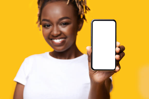 istock Cheerful black woman showing smartphone with blank screen 1284048168