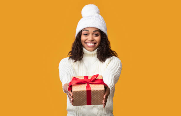 istock African American Woman Giving Present Box To Camera 1284048859