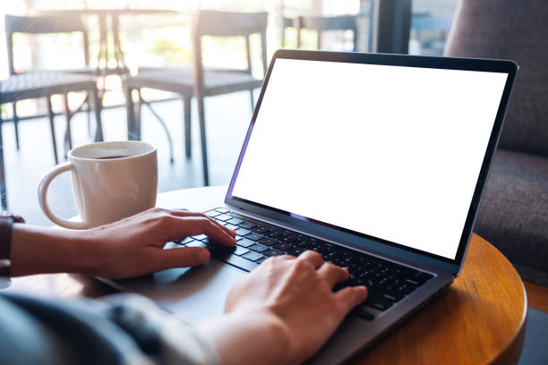 istock a woman using and typing on laptop computer keyboard with blank white desktop screen in cafe 1284048894