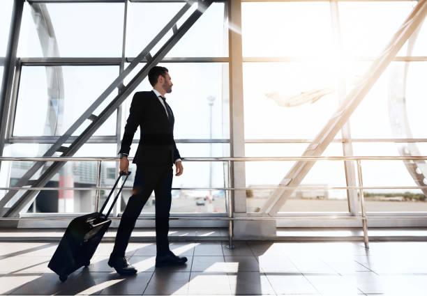 istock Businessman walking by airport terminal, looking through window 1284049274