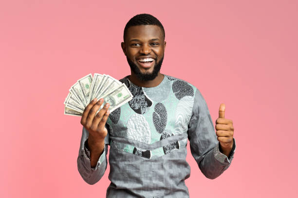 istock Happy black guy holding cash, showing thumb up 1284049422