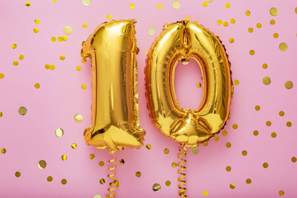 10 air balloon numbers on pink background. 10 k gold foil balloons with confetti. birthday party flat lay with copy space - inflating balloon blowing air imagens e fotografias de stock
