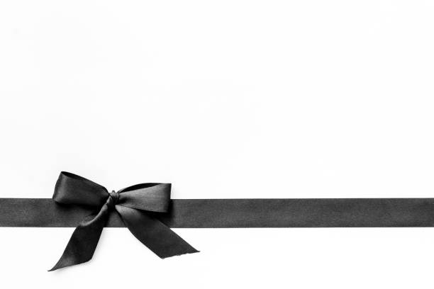 istock Festive black ribbon with bow isolated on white. Top view, copy space 1284050238