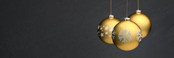 istock Gold colored christmas baubles with different design hanging in front of a black background. Banner size with copyspace. 1284051699