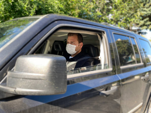 istock Man driving his car with a protection mask 1284052148