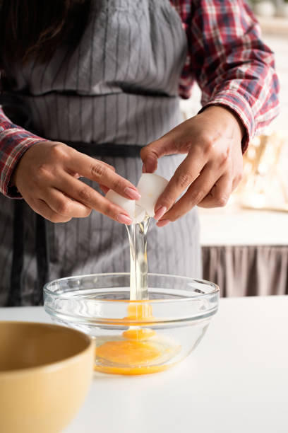 istock woman hands cracking the egg in the kitchen 1284053028