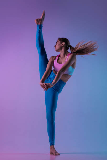 istock Young sportive woman training isolated on gradient studio background in neon light. athletic and graceful 1284053123