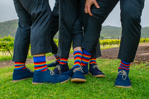 A fee men’s legs with multicoloured Striped Socks and blue leather shoes or traditional Velskoene