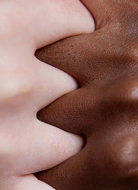 Photo of Diverse hands clasped on pink background