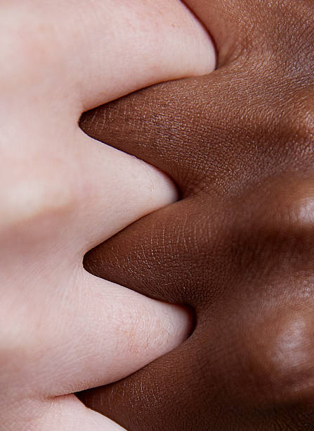 diverse hands clasped on pink background - interlocked imagens e fotografias de stock