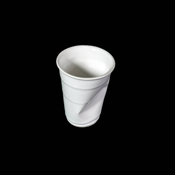 istock Crumpled white disposable paper plastic cup isolated on black 1284056206