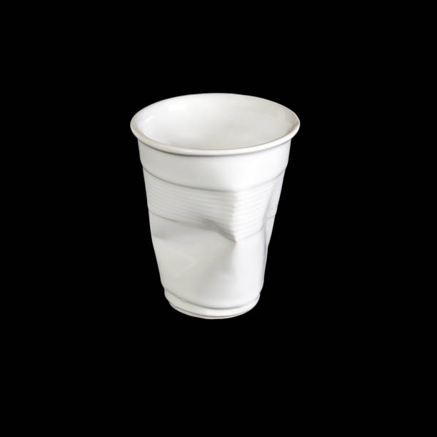 istock Crumpled white disposable paper plastic cup isolated on black 1284056287