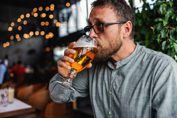 istock Middle aged bearded man sitting in a bar and drinking fresh cold light beer. It's time to relax after work. Always have a little time for yourself. 1284057209