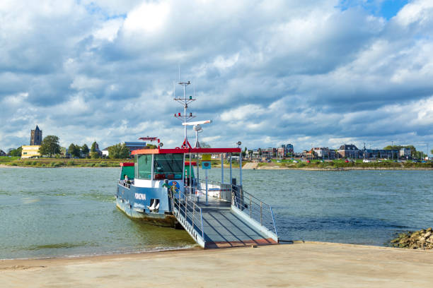 Tiel, Netherlands - October 4, 2020: Skyline of city Tiel with ferry boat crossing the Waal in Betuwe, Gelderland, Netherland