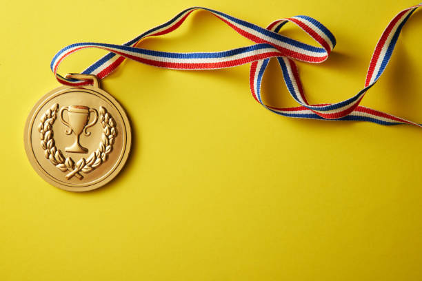 medalla de oro en el fondo de color amarillo - ronda de medalla de oro fotografías e imágenes de stock